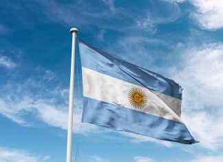 Argentine football club “lack respect” by fielding influencer Argentina flag waving at cloudy sky background. the Argentine Republic flag.