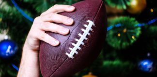NFL reportedly gives Netflix and Amazon Prime nod for Christmas Day hand holding American football ball on Christmas tree background.