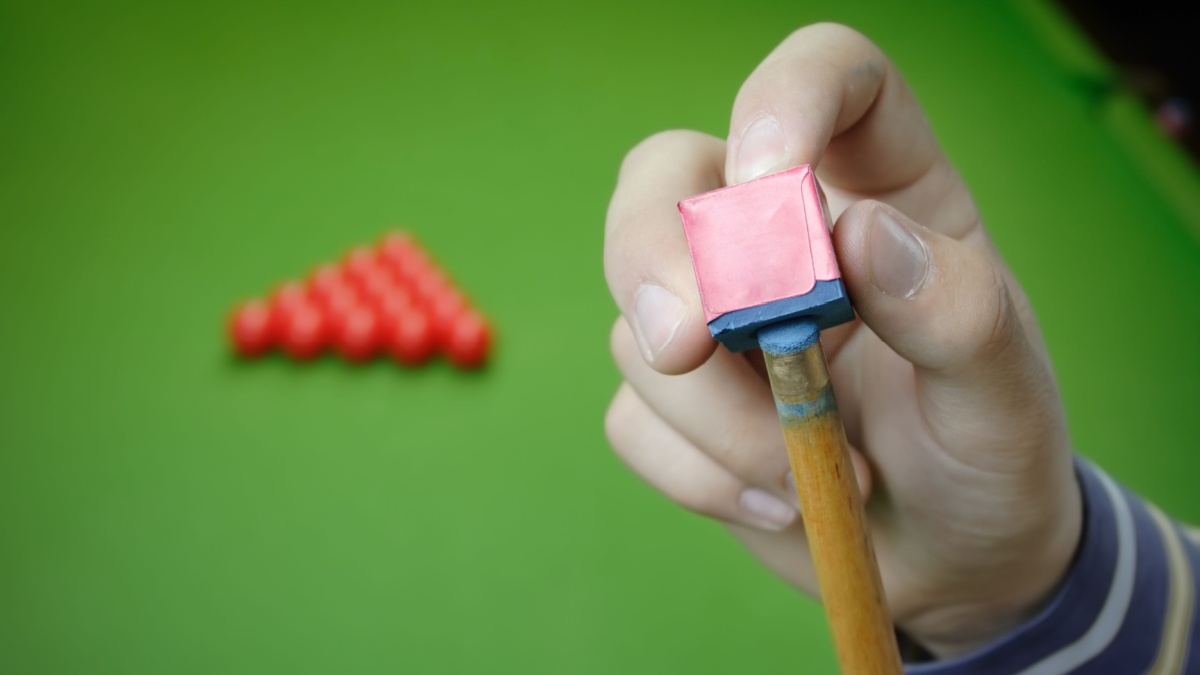 Snooker player preparing for game.