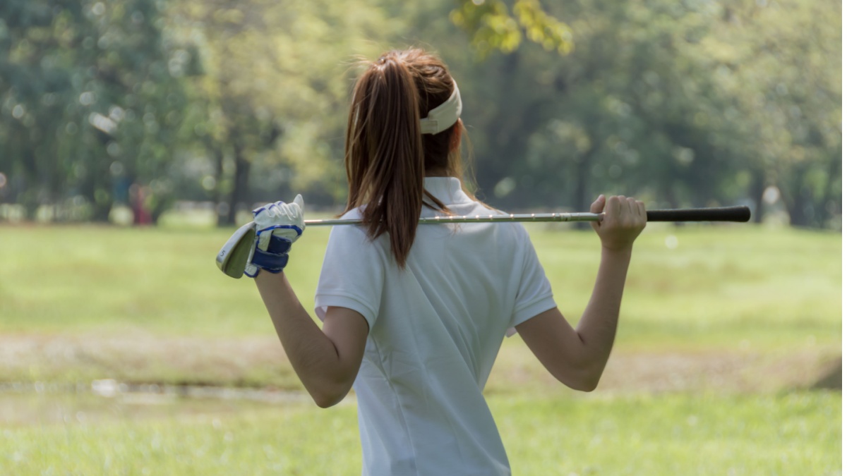 Women's golf Using golf clubs To help twist To warm up body before the play game with blurred soft nature background.