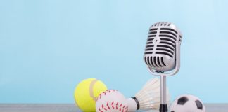 iGaming Daily: Insider Sport’s highlights and predictions Concept sports commentator : The retro microphone put on the wooden table with football or soccer , tennis ball , baseball and shuttlecock isolated on blue background.