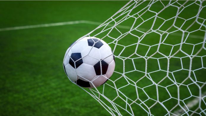Football on goal with net background, football player shoot a leather foot ball for make a score, Peru.