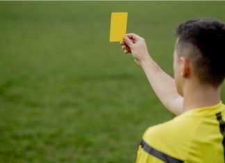 Kike Salas arrested over alleged sports betting scandal Referee showing a red card to a displeased football or soccer player while gaming. Concept of sport, rules violation, controversial issues, obstacles overcoming.