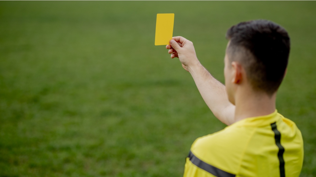 Referee showing a red card to a displeased football or soccer player while gaming. Concept of sport, rules violation, controversial issues, obstacles overcoming.