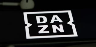 DAZN to broadcast celebrity-backed E1 racing series globally Rheinbach, Germany 5 June 2021, The logo of the streaming service "DAZN" on the screen of a smartphone with white headphones and a remote control.