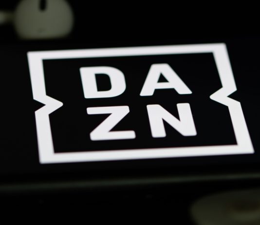 DAZN ruling shields Pro League from Ligue 1 situation Rheinbach, Germany 5 June 2021, The logo of the streaming service "DAZN" on the screen of a smartphone with white headphones and a remote control.