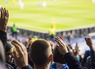 MPs debate: Could football “do without” gambling? Fans clapping their hands at a football stadium.