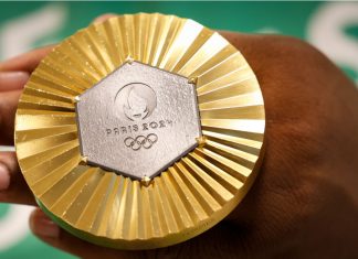Olympics gets new leader as Kirsty Coventry takes gold in vote Gold medal of Paris 2024 Olympic Games handheld detail shot, sports competition winner symbol.