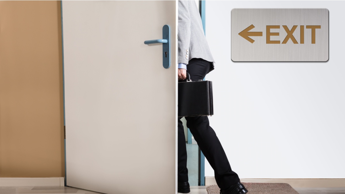 Businessperson Walking Out With Exit Sign On Wall.
