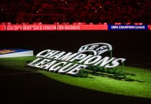 Football reigns as king of crypto investment, but for how long? UEFA Champions League logo on pitch.