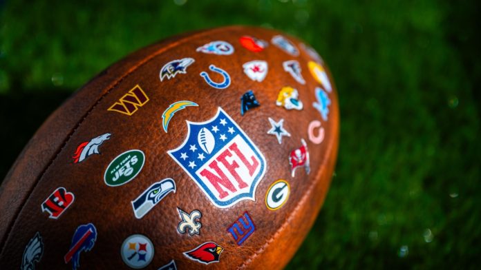 nfl-diversity A photo of an American football with the NFL's team logos stitched