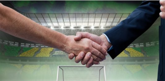 Composition of businessmen shaking hands over sports stadium. sports, deal, agreement and competition concept digitally generated image.