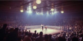 Has Zuffa Boxing and Netflix proven a new model can work? Blurred background of a captivating view of an iconic boxing arena featuring a spotlight on the ring, surrounded by a large audience, capturing the excitement and energy of the event.