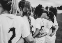 Damning report uncovers football’s discrimination crisis Female football players huddling together.