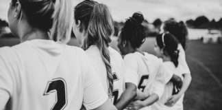 Damning report uncovers football’s discrimination crisis Female football players huddling together.