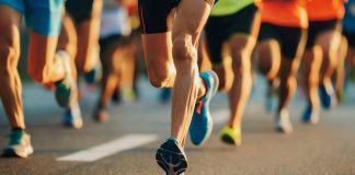 Garmin runs into legal trouble with Strava Close-Up of Marathon Runners' Legs on City Road During Athletic Competition.