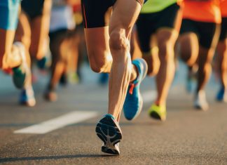 Garmin runs into legal trouble with Strava Close-Up of Marathon Runners' Legs on City Road During Athletic Competition.