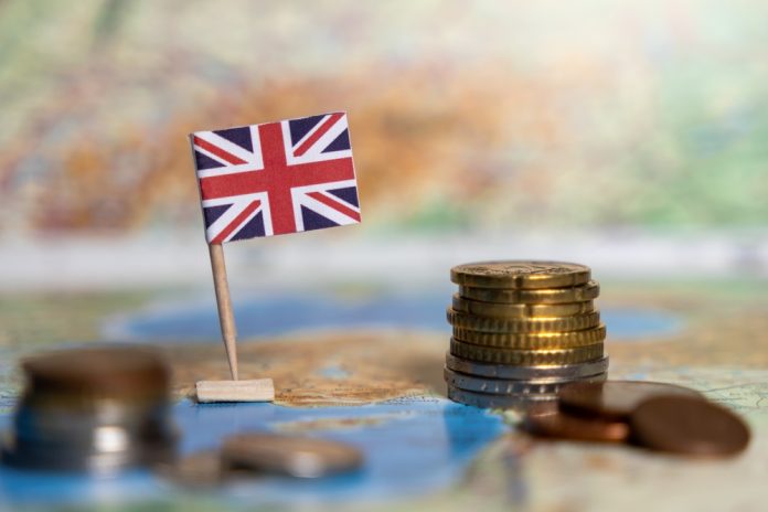 British,Flag,With,Stacked,Coins,On,A,World,Map,,Symbolizing british flag with stacked coins on a world map, symbolizing the economy, financial system, and trade of the united kingdom