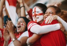 Why men’s sports can’t afford to lose female fans English female soccer fans with England flag painted on their faces hugging each other after their team's victory. English female spectators in football stadium celebrating their team's victory.