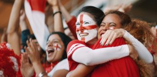 Why men’s sports can’t afford to lose female fans English female soccer fans with England flag painted on their faces hugging each other after their team's victory. English female spectators in football stadium celebrating their team's victory.