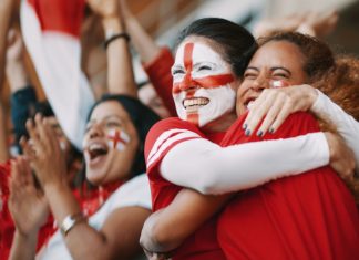 Why men’s sports can’t afford to lose female fans English female soccer fans with England flag painted on their faces hugging each other after their team's victory. English female spectators in football stadium celebrating their team's victory.