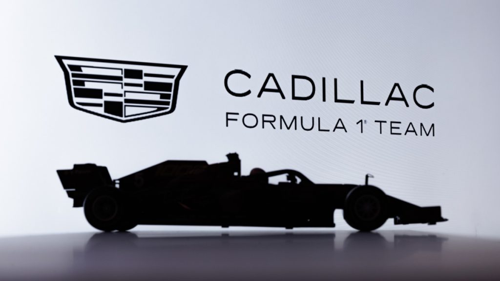 Porto, Portugal - October 31st, 2025: Cadillac F1 Team Logo on a Screen with Silhouette Profile of Toy Formula One Car