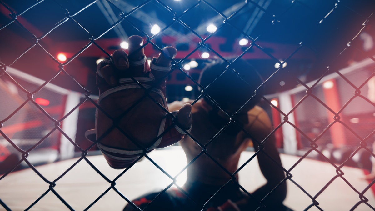 Portrait man MMA fighter on octagon ring. Fighting Championship, dark background.