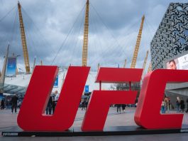 Former UFC fighter called out for illegal gambling sponsorship London, UK. April 2, 2025. The O2 Arena in London features its iconic dome and yellow masts, a red UFC sign in the foreground, modern buildings, and a cloudy sky above.