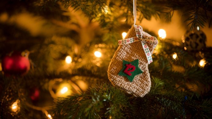 Traditional Advent Calendar Stocking with the date of the twelfth of December hanging on a traditional christmas tree.