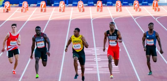 GOLD COAST, AUSTRALIA - APRIL 08, 2018: Yohan Blake of Jamaica (C) compete in the athletic's men's 100m heats during the 2018 Gold Coast Commonwealth Games at the Carrara Stadium.