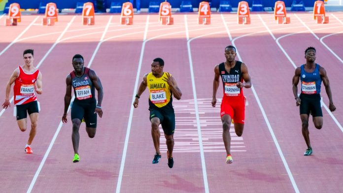 GOLD COAST, AUSTRALIA - APRIL 08, 2018: Yohan Blake of Jamaica (C) compete in the athletic's men's 100m heats during the 2018 Gold Coast Commonwealth Games at the Carrara Stadium.