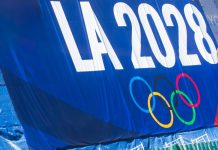 Los Angeles 2028 closes in on record Games sponsorship after $2bn milestone 2024-11-20 Los Angeles USA A promotional banner for the LA 2028 Olympics featuring the Olympic rings, displayed on a blue background with a green fence below.