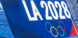 Los Angeles 2028 closes in on record Games sponsorship after $2bn milestone 2024-11-20 Los Angeles USA A promotional banner for the LA 2028 Olympics featuring the Olympic rings, displayed on a blue background with a green fence below.