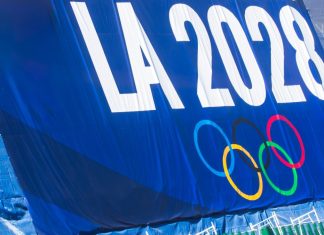 Los Angeles 2028 closes in on record Games sponsorship after $2bn milestone 2024-11-20 Los Angeles USA A promotional banner for the LA 2028 Olympics featuring the Olympic rings, displayed on a blue background with a green fence below.