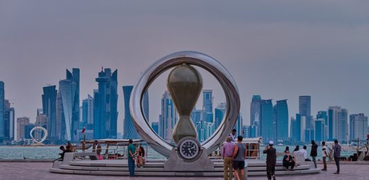 Doha, Qatar-April 20 2025:The FIFA World Cup Qatar 2022 Official Countdown Clock with people walking and Doha skyline in background.