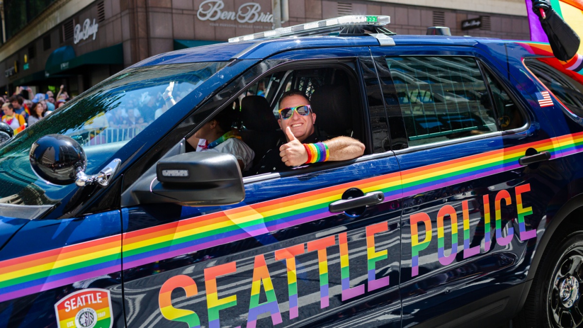 Seattle, WA / USA - 30 June 2019: A Seattle police officer passes by in a cruiser during the Seattle Pride Parade showing support for LGBTQ rights.