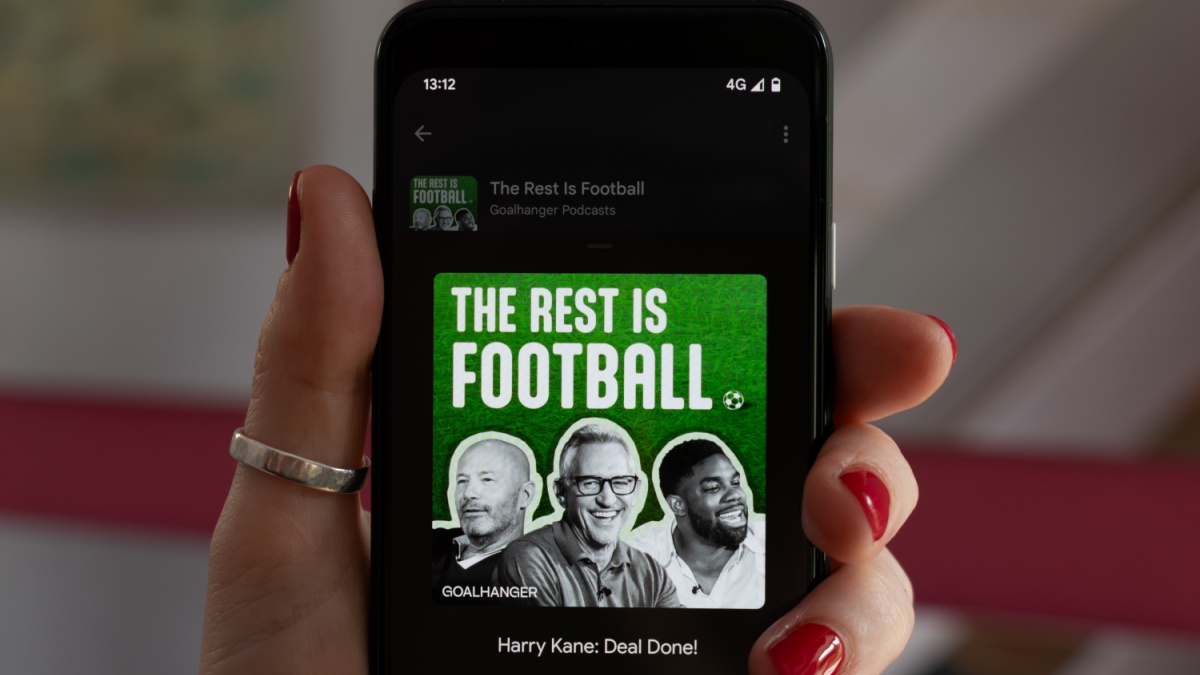 Hebden Bridge, West Yorkshire UK. August 17, 2023. The Rest is Football podcast playing on a Google Pixel 4 mobile phone. Woman's hand with red nails. Episode Harry Kane with Gary Lineker.