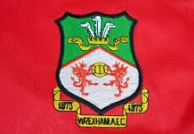 Wrexham land Apollo funding for stadium redevelopment Close up of Wrexham AFC badge on 2001-02 home kit jersey – Wales, UK – 9 January 2024.