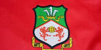 Wrexham land Apollo funding for stadium redevelopment Close up of Wrexham AFC badge on 2001-02 home kit jersey – Wales, UK – 9 January 2024.