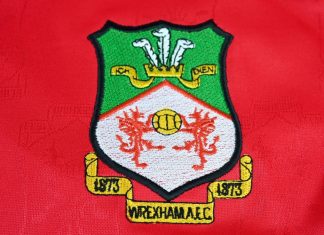 Wrexham land Apollo funding for stadium redevelopment Close up of Wrexham AFC badge on 2001-02 home kit jersey – Wales, UK – 9 January 2024.