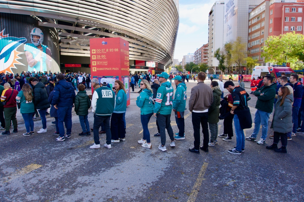 MADRID, SPAIN - NOVEMBER 16, 2025: Fans wearing team gear and cheering outside the Santiago Bernabéu Stadium ahead of the NFL Regular Season game between the Miami Dolphins and the Washington Commande