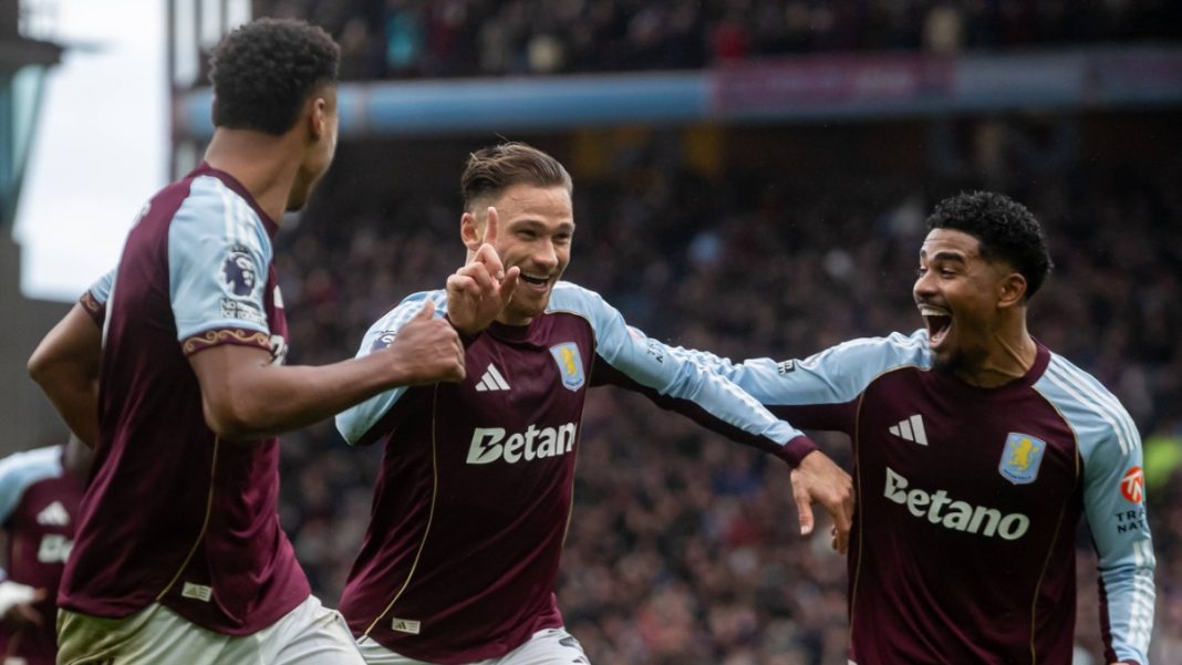 Aston Vila players in Premier League match with Betano betting sponsor on front-of-shirt.