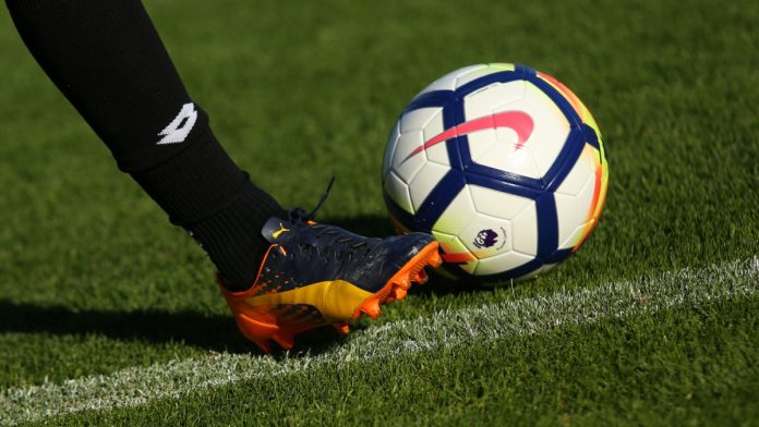 LONDON, ENGLAND - JULY 26, 2017: New Nike Ordem 5 ball. Football player in Puma boots shoots the Official Premier League Ball.