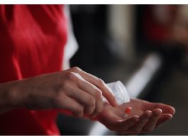 Do the Enhanced Games still work if the drugs don’t? Soccer player, hands and pills with vitamin supplement for sport, challenge or competition in locker room. Closeup, person or athlete with medication, antibiotic or prescription for game or match.