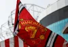 Disney+ finds backdoor into Manchester United’s fanbase Red Manchester United flag with club crest blows in the wind near Old Trafford stadium.