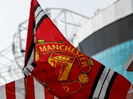 Disney+ finds backdoor into Manchester United’s fanbase Red Manchester United flag with club crest blows in the wind near Old Trafford stadium.