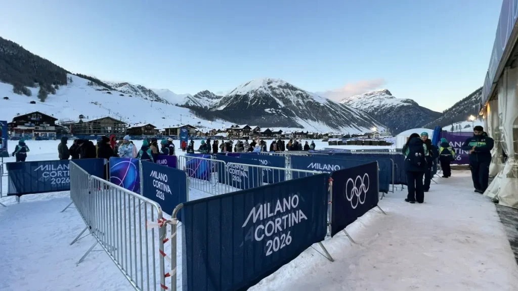 Milano Cortina 2026 Olympic crowd at barriers with flags and snowy mountains during winter games in Livigno, Italy.