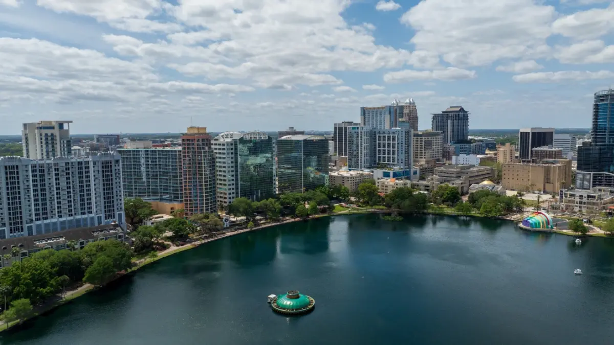 Orlando, Florida, USA - March 27th 2024: Downtown Orlando skyline overlooking the tranquil Lake Eola Park with its iconic fountain and urban backdrop.