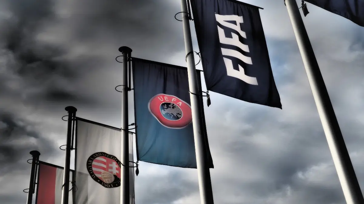 Budapest, Hungary - October 19, 2020: FIFA, UEFA and Hungarian Football Association flags in front of the Hungarian Football Association headquarters building in Budapest, Hungary in dramatic tone.
