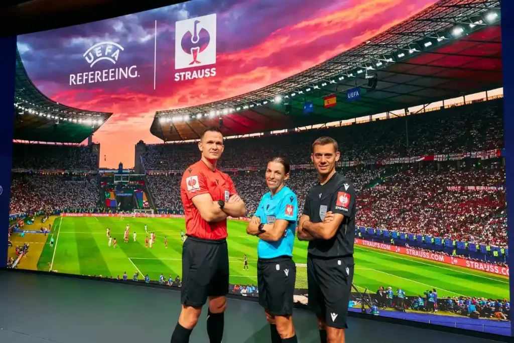 UEFA referees with STRAUSS sponsor. 